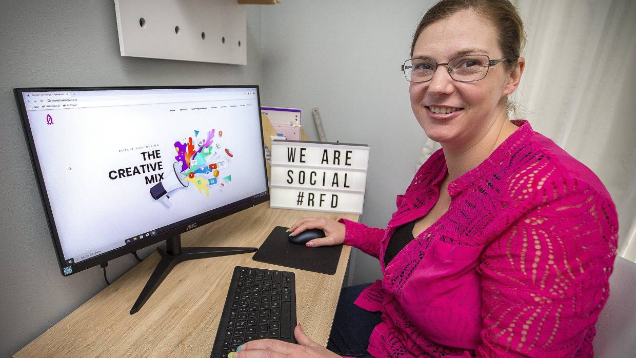 Lainey Founder of Rocket Fuel Design smiling at her Desk