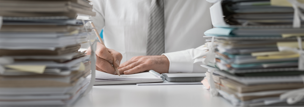 Man with paper work piled up around him